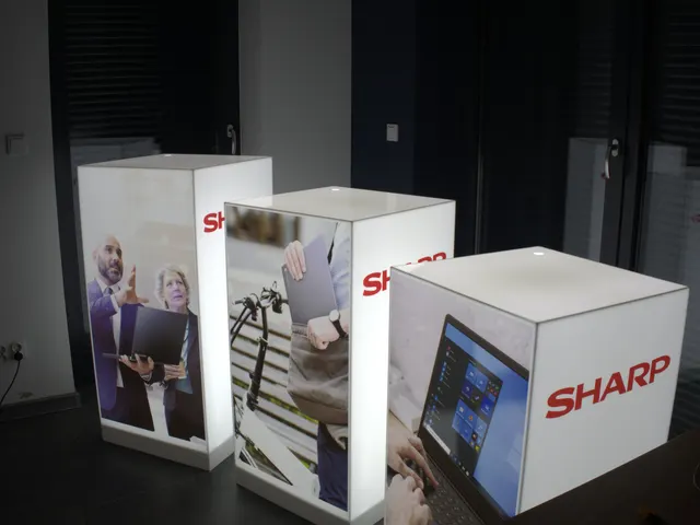 Trzy podświetlane kubiki ekspozycyjne różnej wysokości z grafikami i logotypami Sharp i Dynabook w showroomie